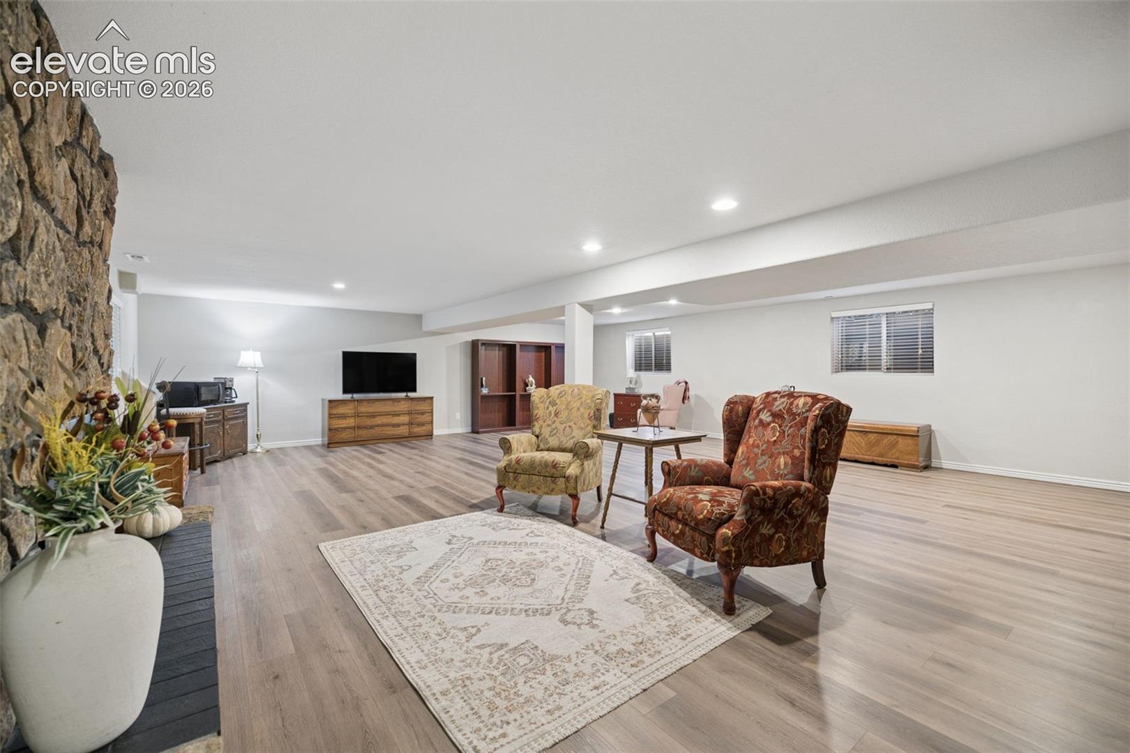 Basement is open concept and features LVP flooring and gas fireplace with stone surround