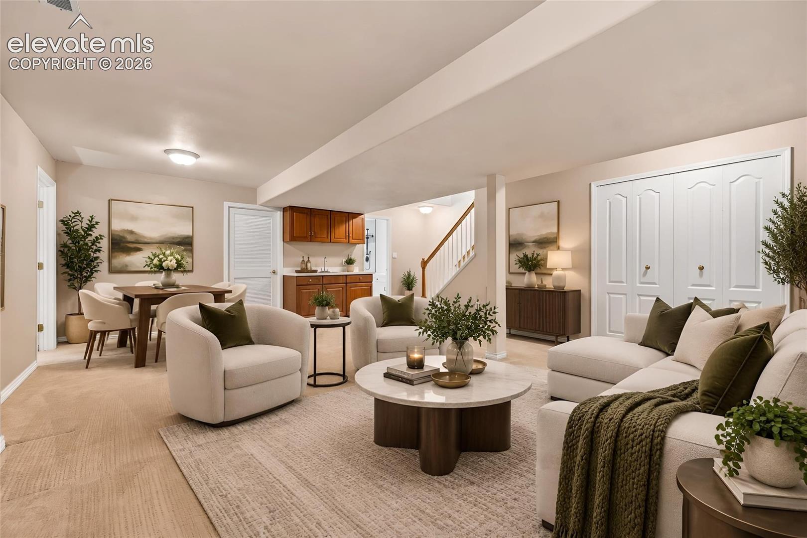 Open-concept area featuring a wet bar with wooden cabinetry, carpeted flooring, double-door closet storage, and a wooden staircase with a white railing