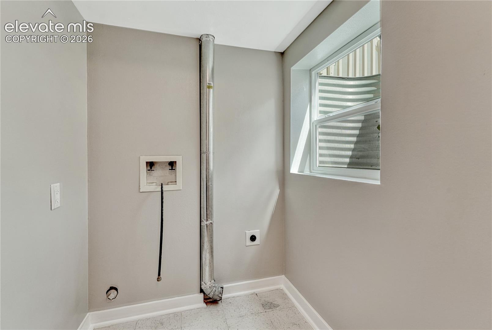 Utility space featuring a window, light gray wall paint, and resilient flooring