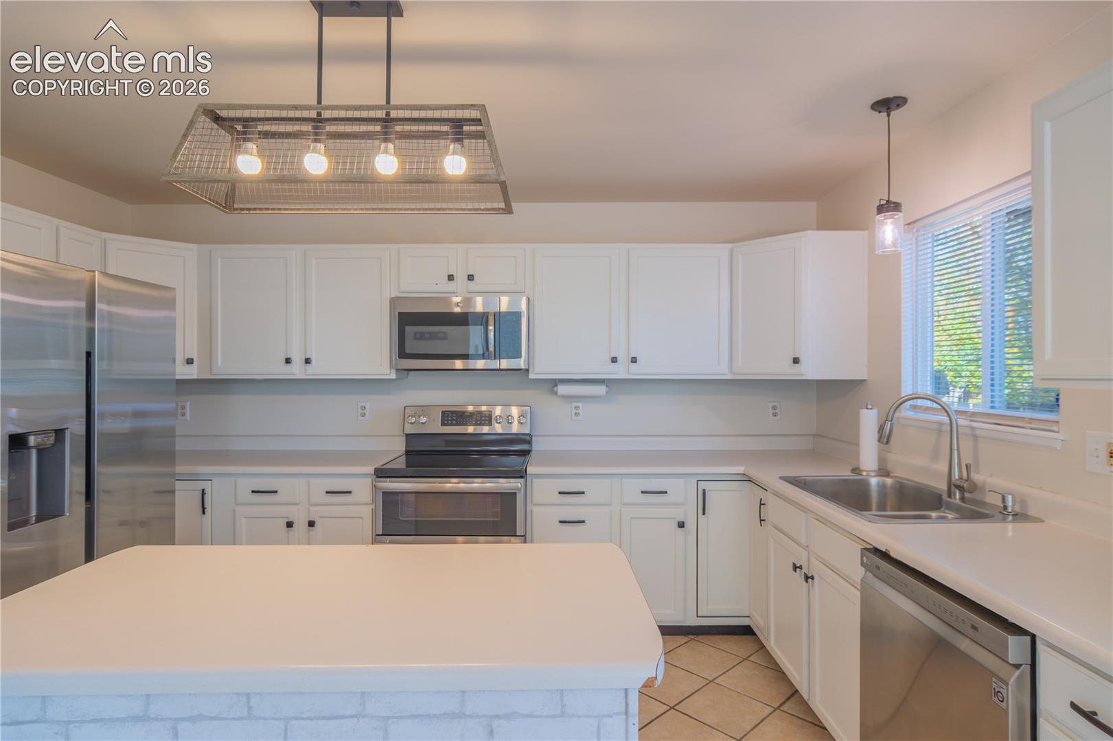 A spacious, functional layout with an electric smooth-top range, double-basin sink, and center island.