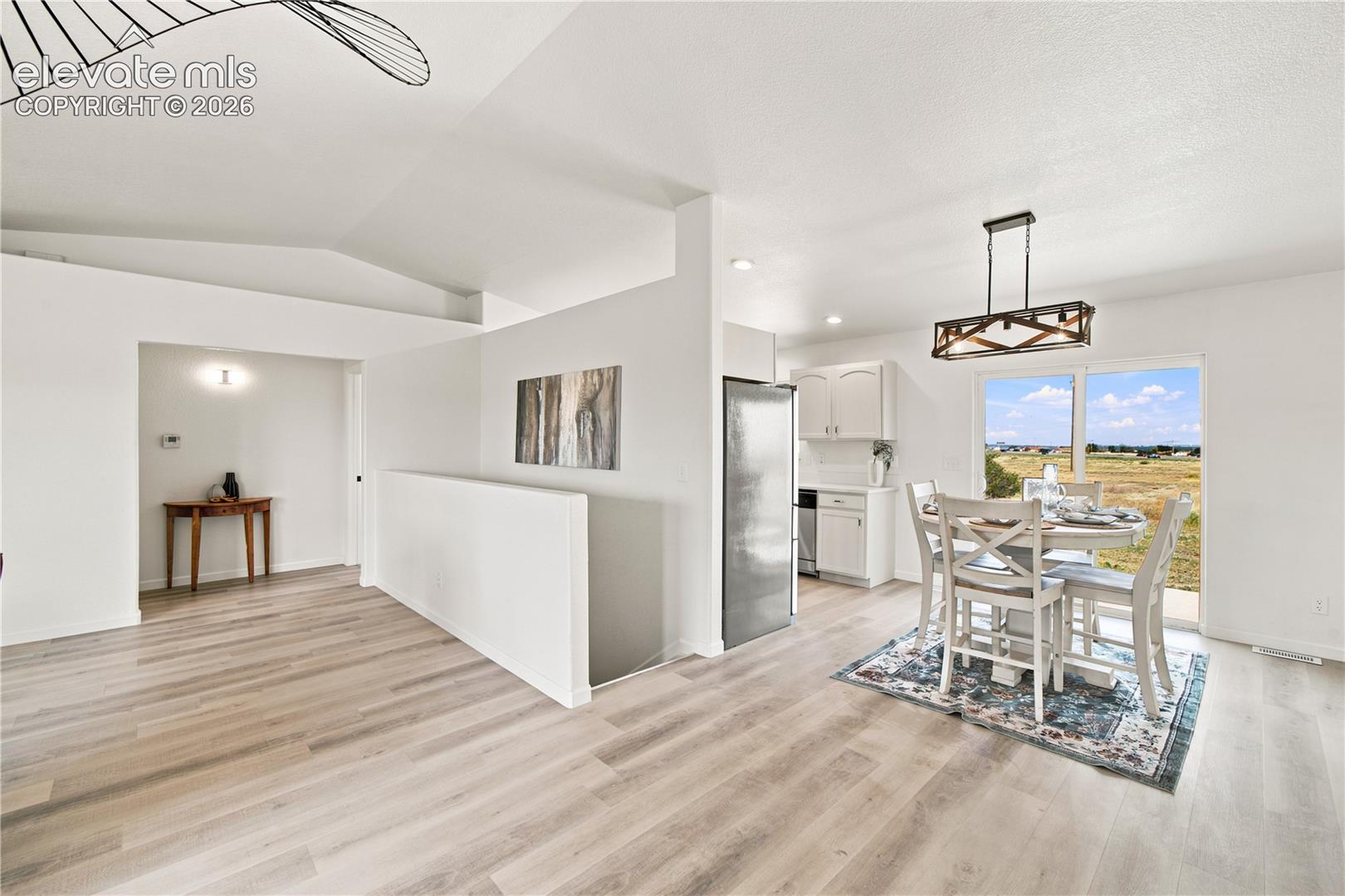 Open-concept living area with light wood-finish flooring