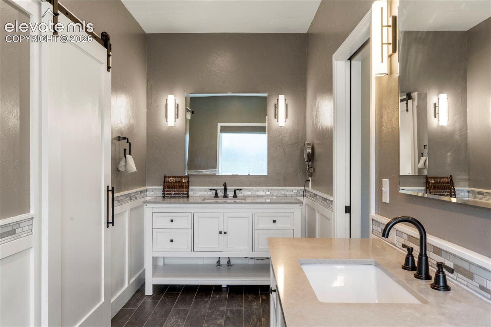 Bathroom featuring vanity, wood tiled floors, and backsplash