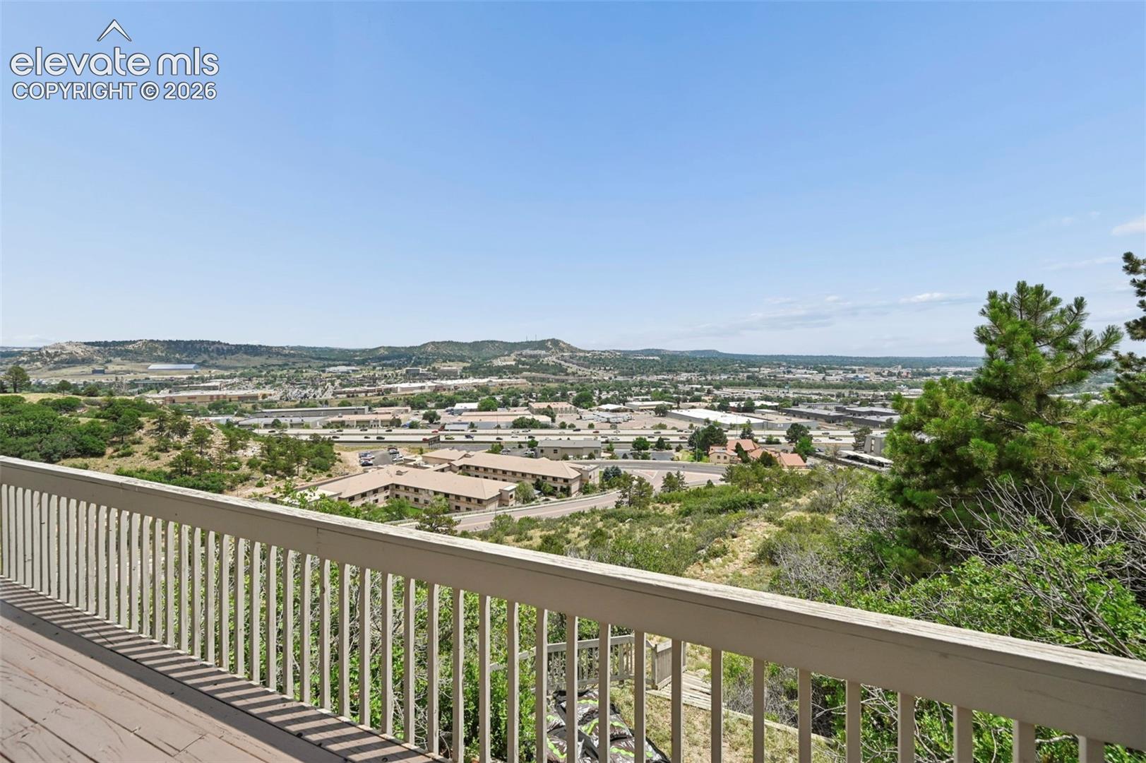 Expansive outdoor deck with white railing, offering elevated regional scenery