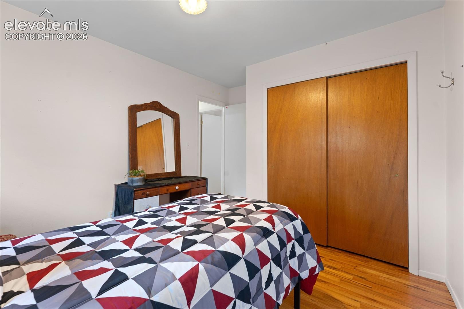 Hardwood flooring and a built-in closet with sliding wood doors