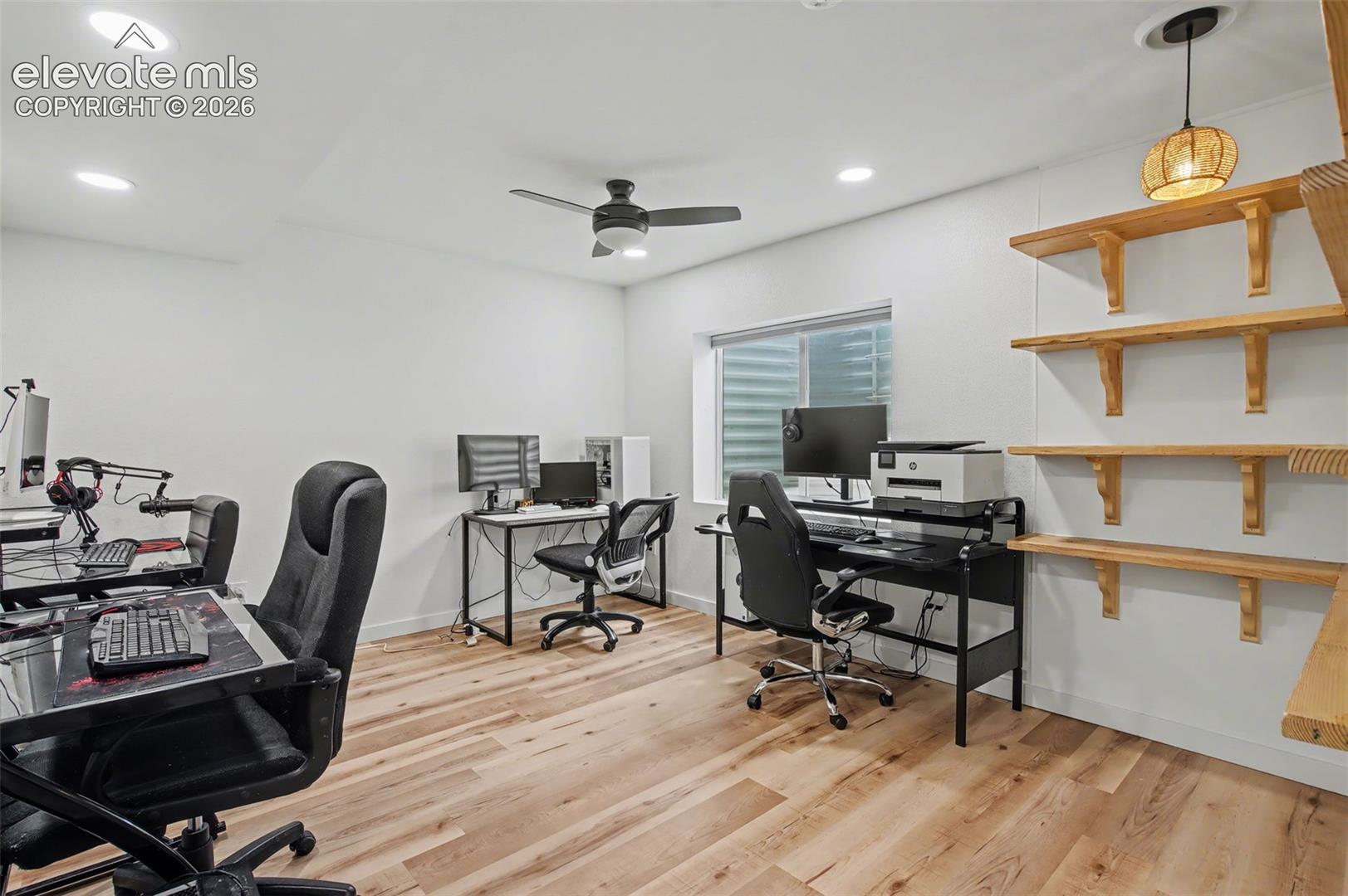 Wood-finish flooring, recessed lighting, ceiling fan with light kit, and natural wood floating wall shelving