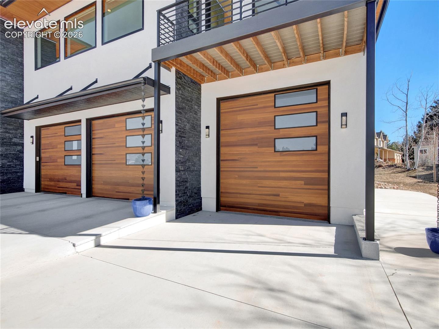 Contemporary exterior with a five-car garage with RV storage featuring wood-finish doors with horizontal window inserts