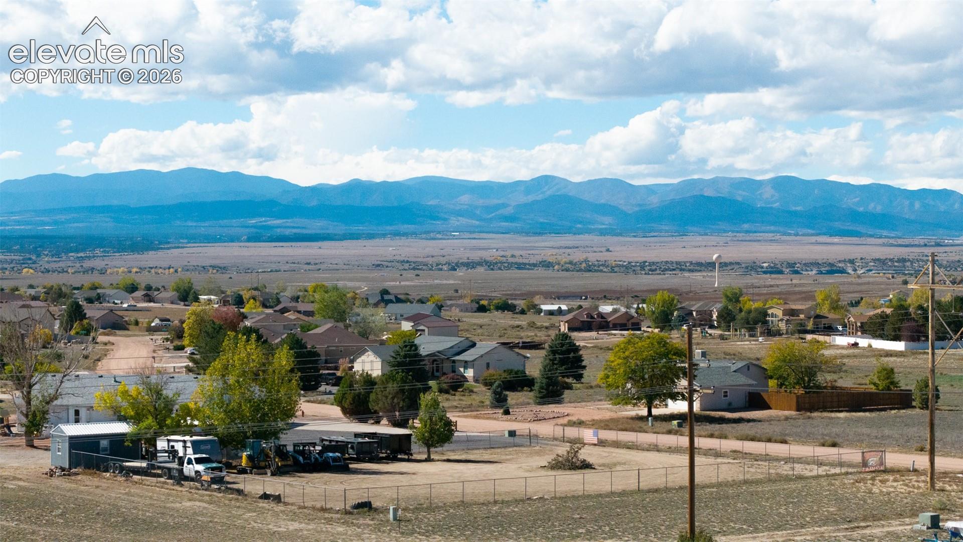 Expansive landscape featuring panoramic mountain horizons, mature trees, and large-lot residential zoning