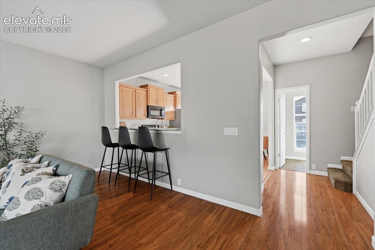 Wood flooring throughout, breakfast bar, natural wood cabinetry.