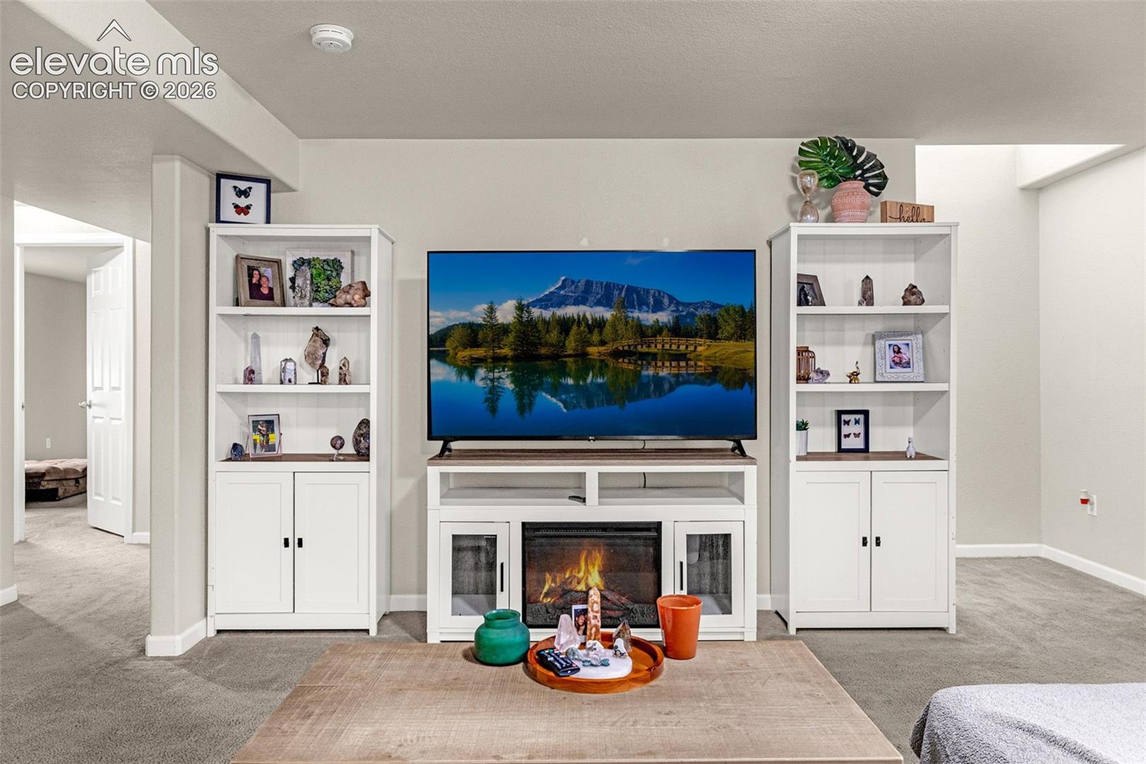 Built-in media console with integrated electric fireplace and flanking storage towers