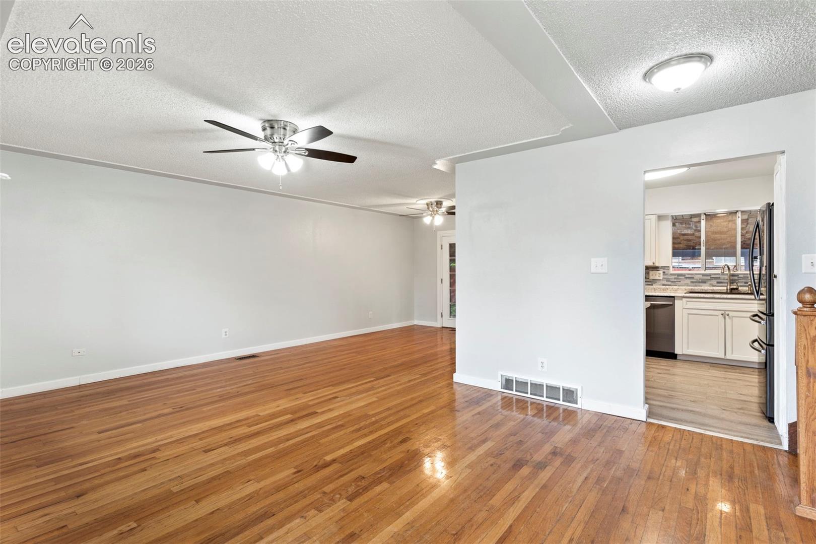 Hardwood flooring throughout the main area and a ceiling fan