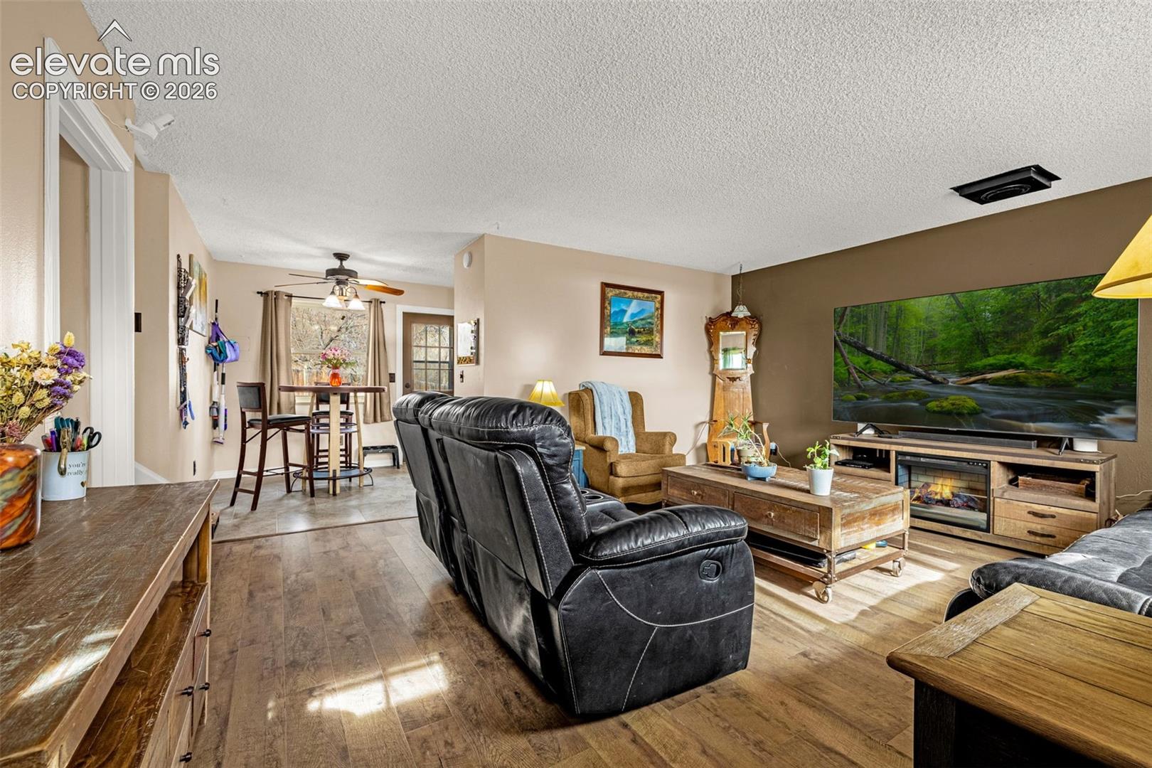 Wood-finish flooring, textured ceiling, and built-in electric fireplace console