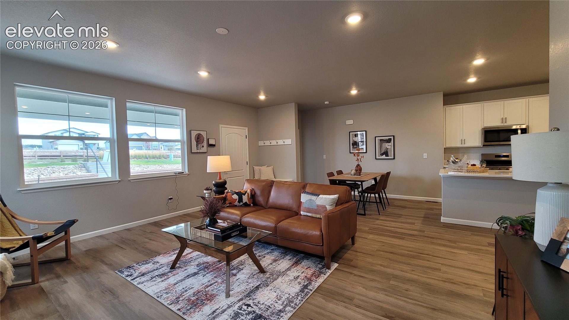 Open-concept interior featuring LVP flooring, LED lighting, and large windows!