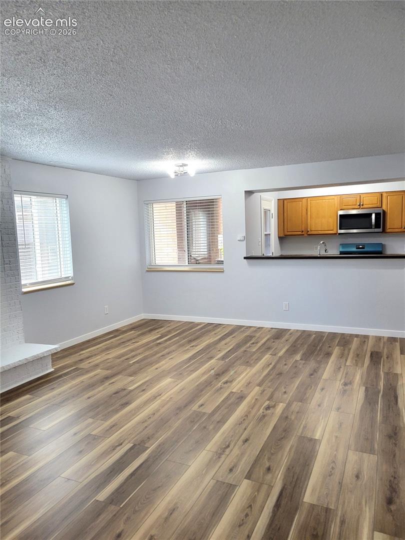 Spacious living area featuring wood-finish flooring throughout