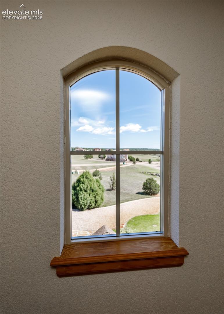 Arched window featuring a multi-pane grid and a natural wood-finish sill