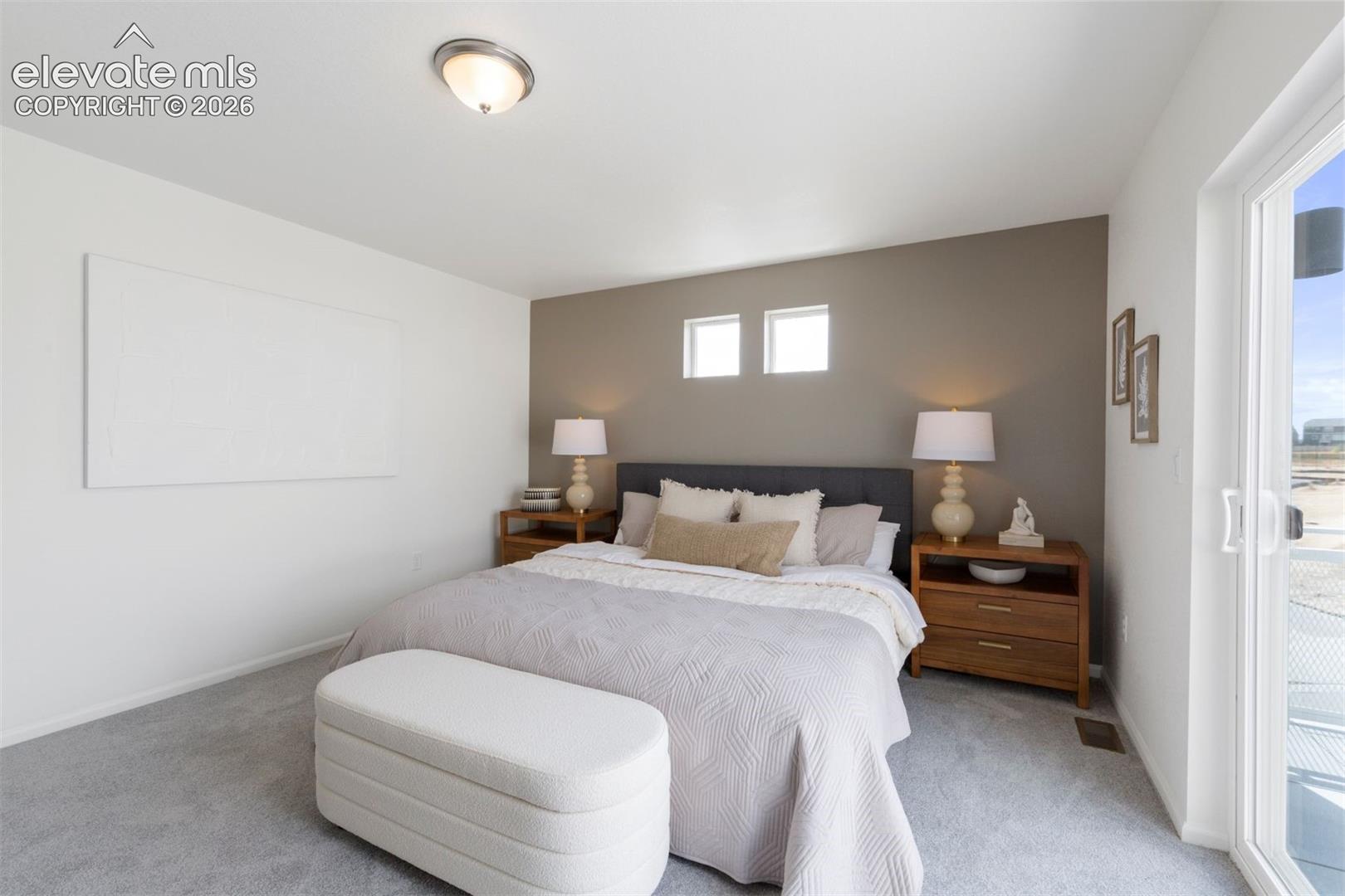 Recessed ceiling light fixture, two transom windows, gray carpet flooring, sliding glass door, and a two-tone wall finish
*photos of a model home*