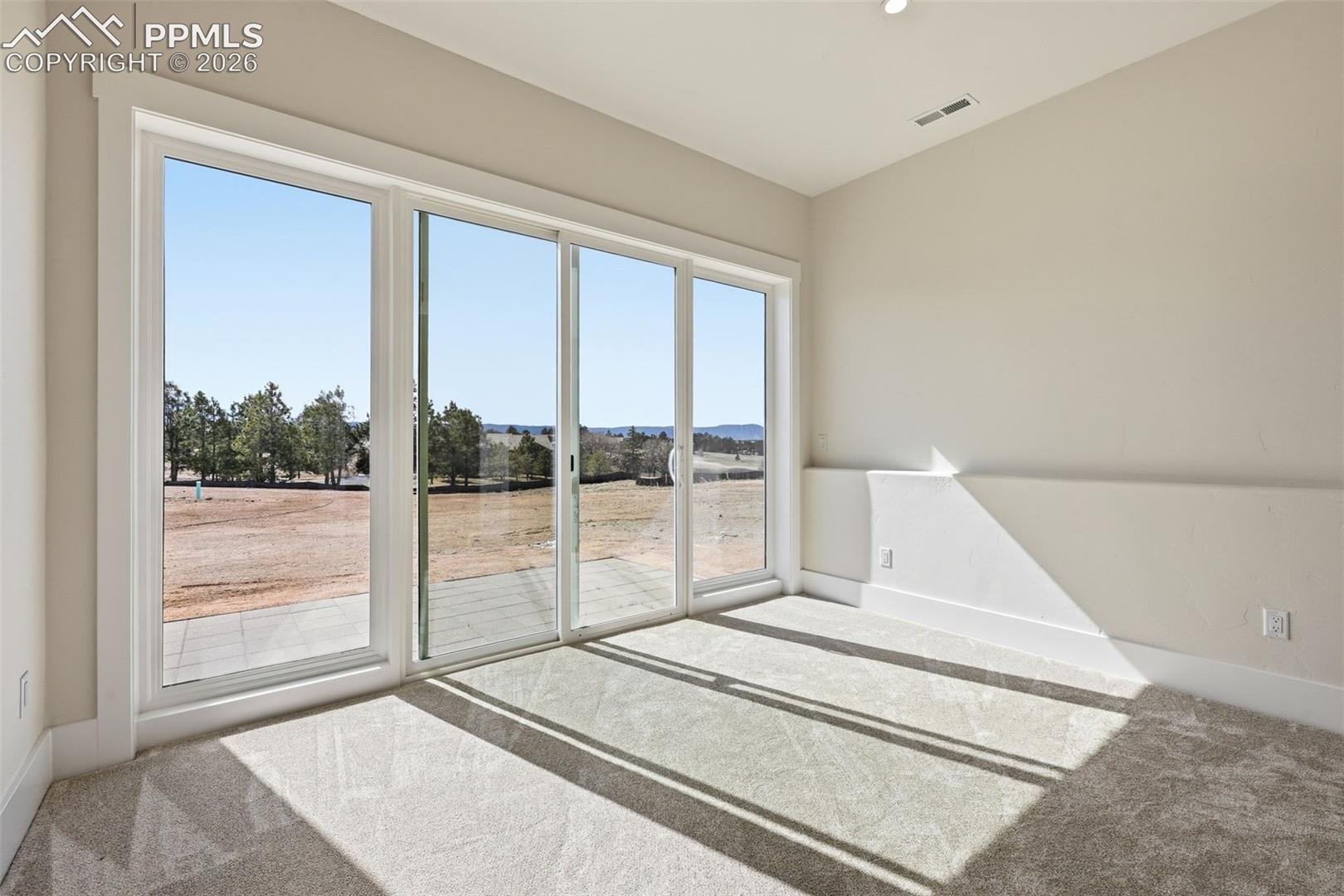 Carpeted empty room featuring baseboards
