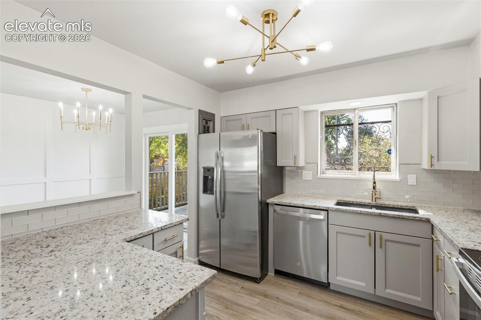 Kitchen featuring light-toned cabinetry, light granite-style countertops, and stainless steel appliances