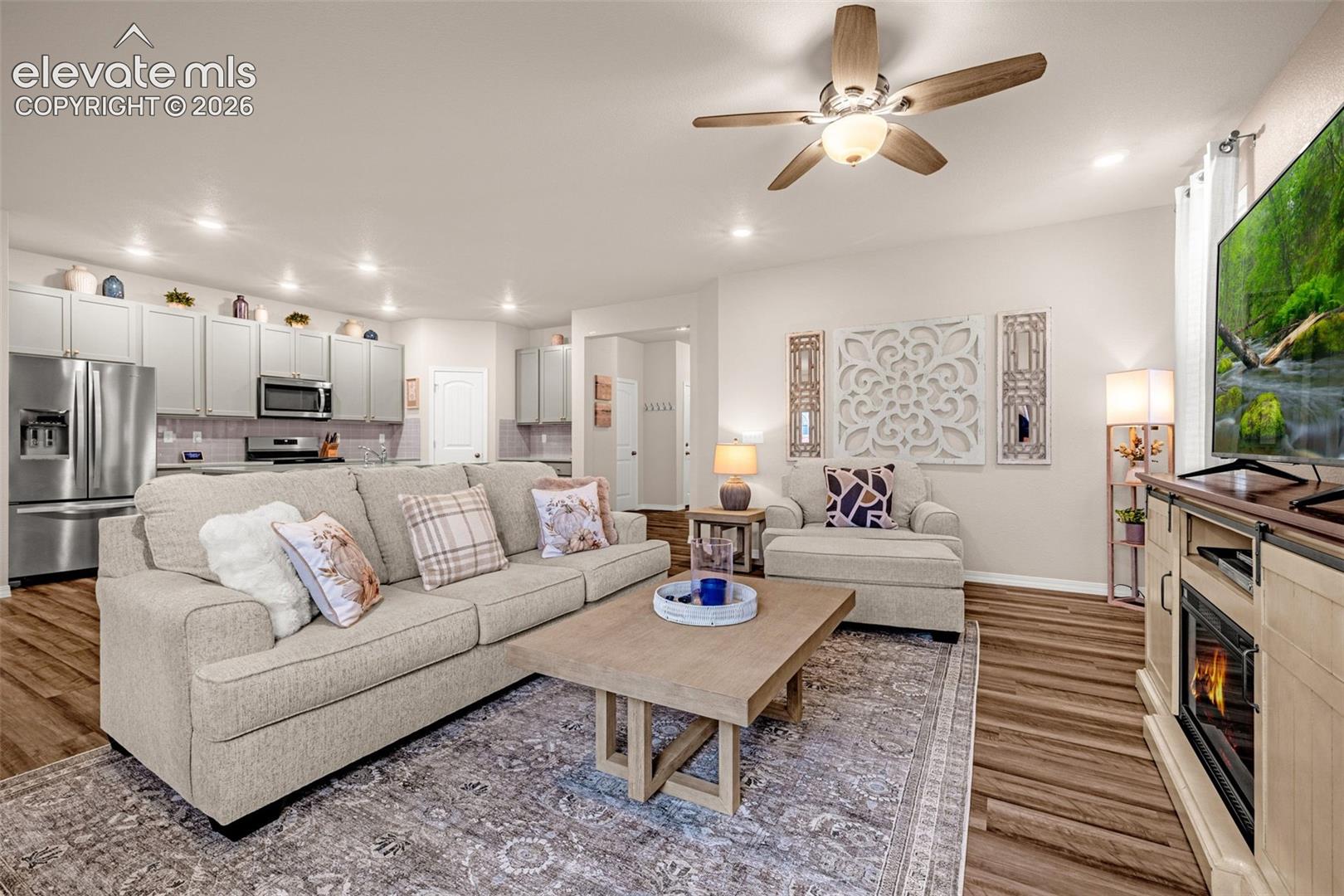 Recessed lighting, wood-finish flooring, ceiling fan with integrated lighting, stainless steel appliances, and built-in microwave
