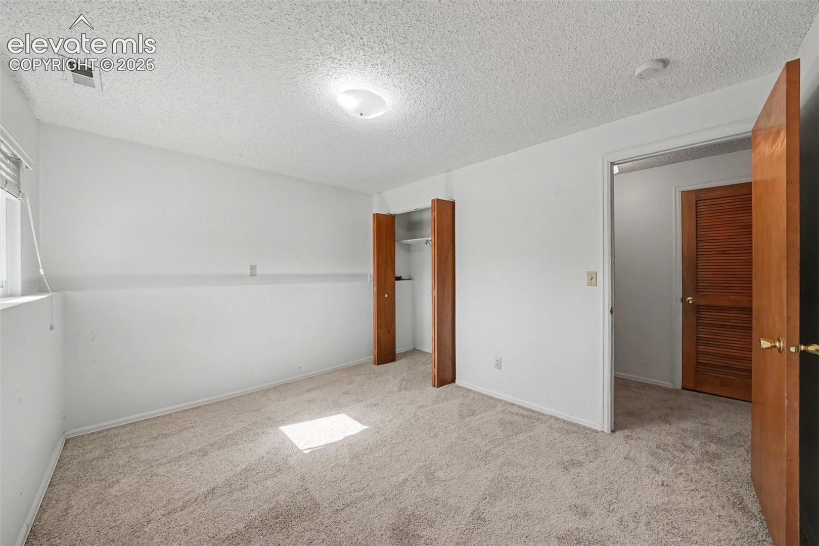 Neutral-toned carpeting, wood-finish interior doors, and built-in closet storage