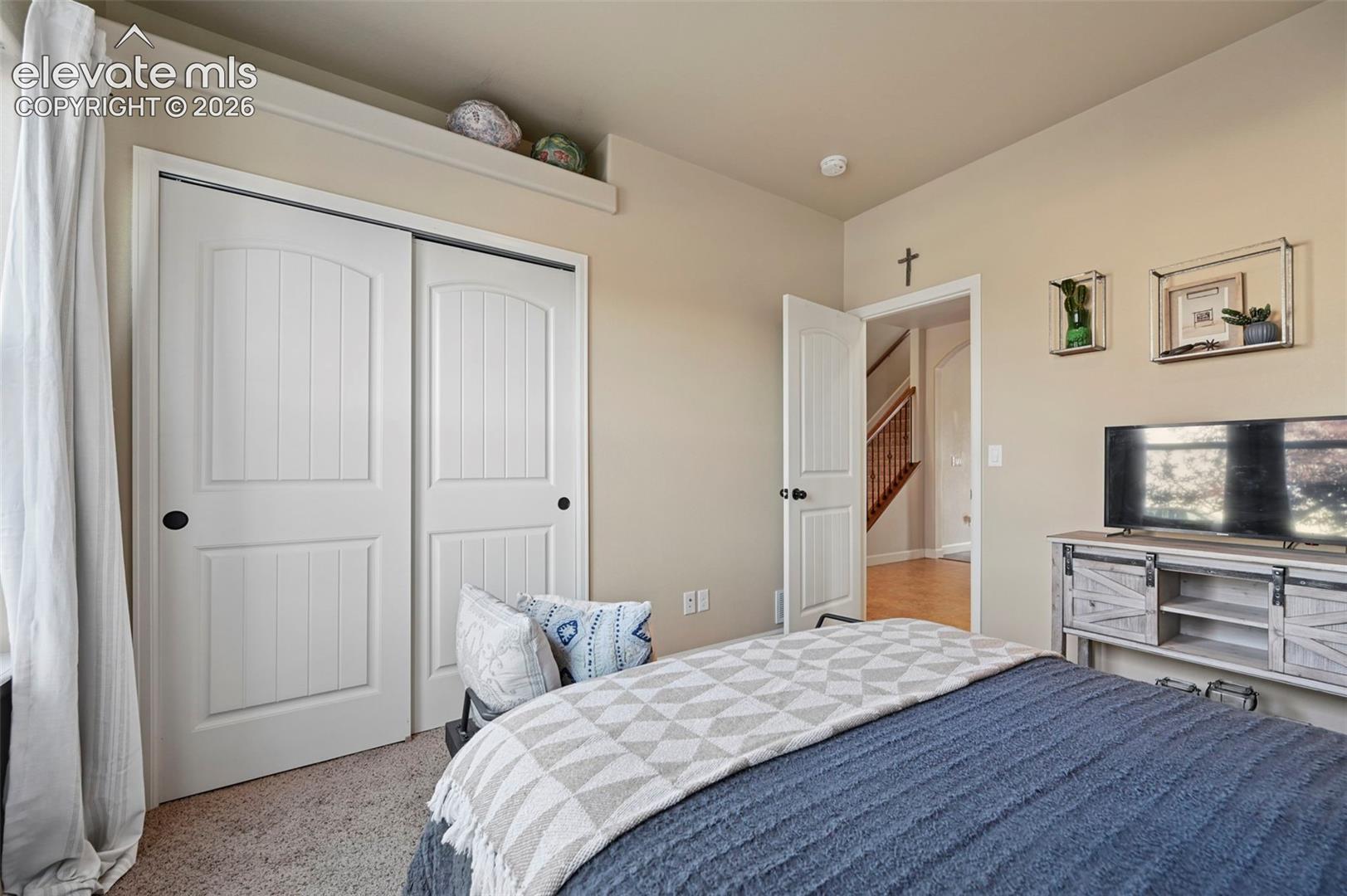 Soft beige wall paint with white trim, textured carpet flooring, and a built-in display shelf