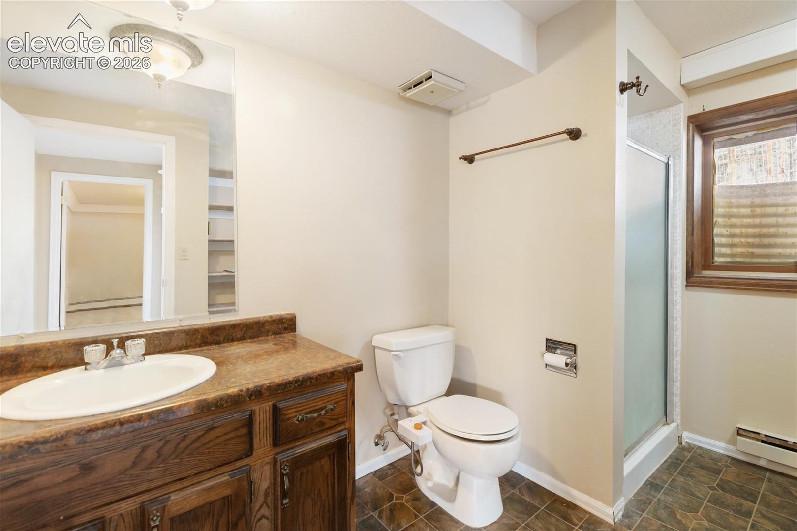 Dark wood-finish vanity with an oval sink and brown countertop