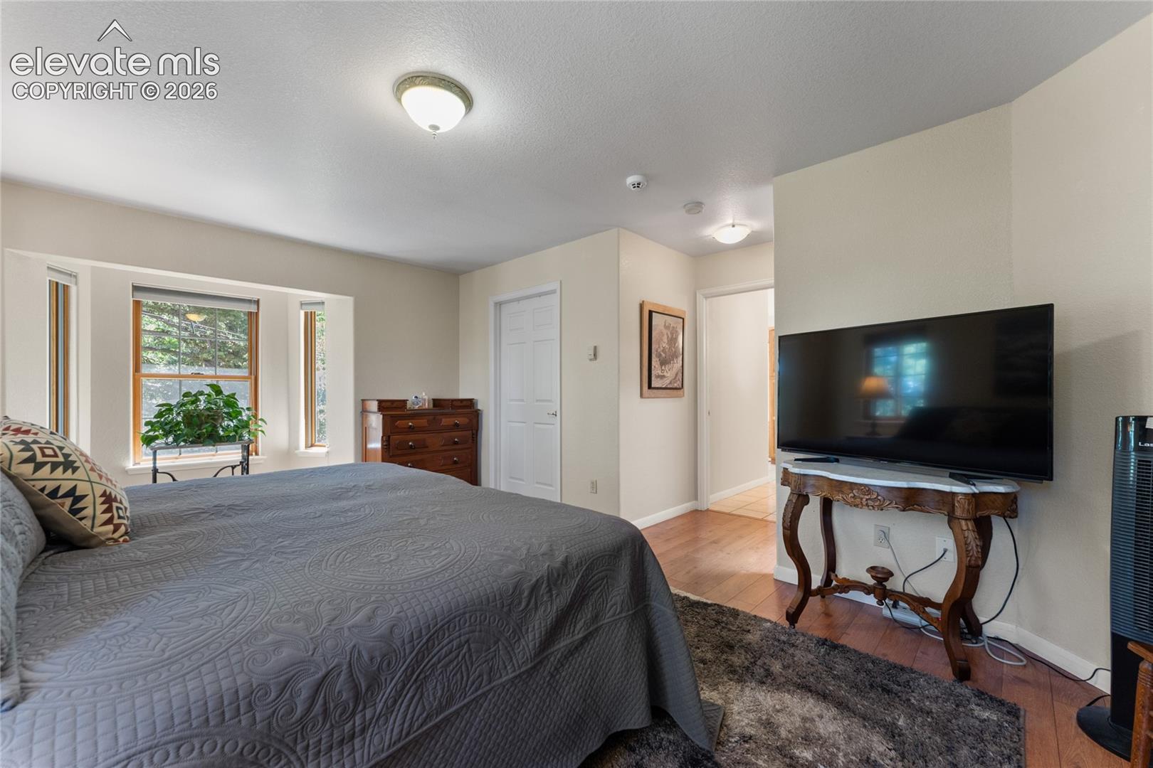 Bedroom featuring multiple windows, recessed lighting, and wood-finish flooring