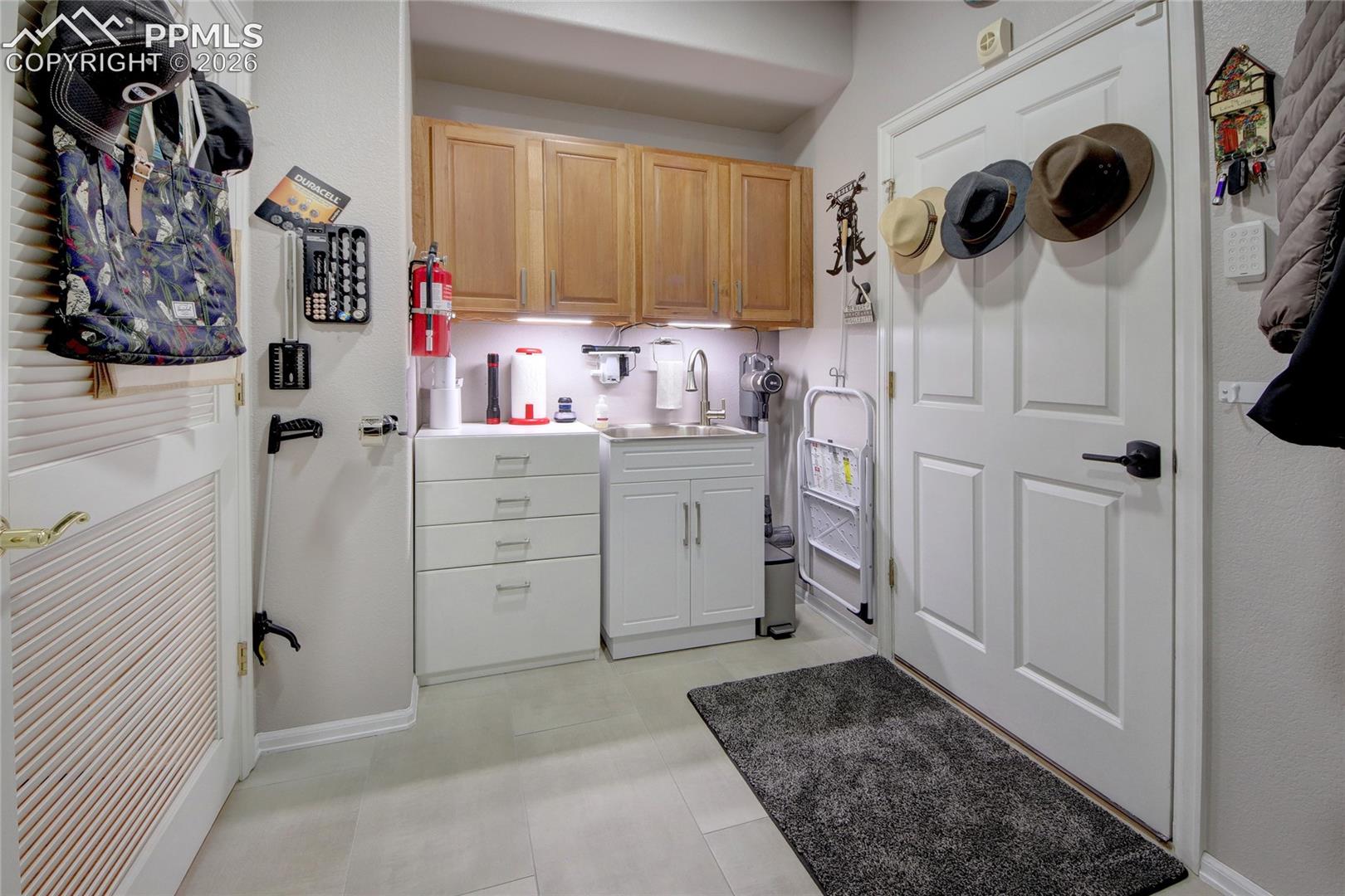 Laundry room with sink and next to garage