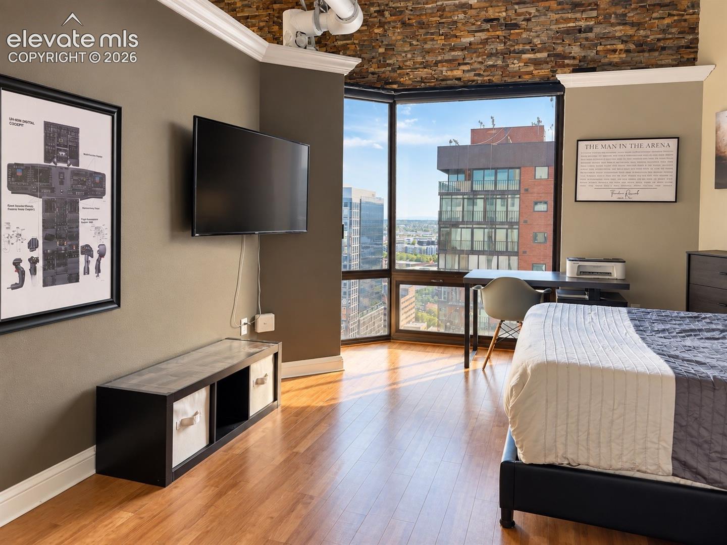 Hardwood-finish flooring, full-height corner windows, and a stacked stone accent wall