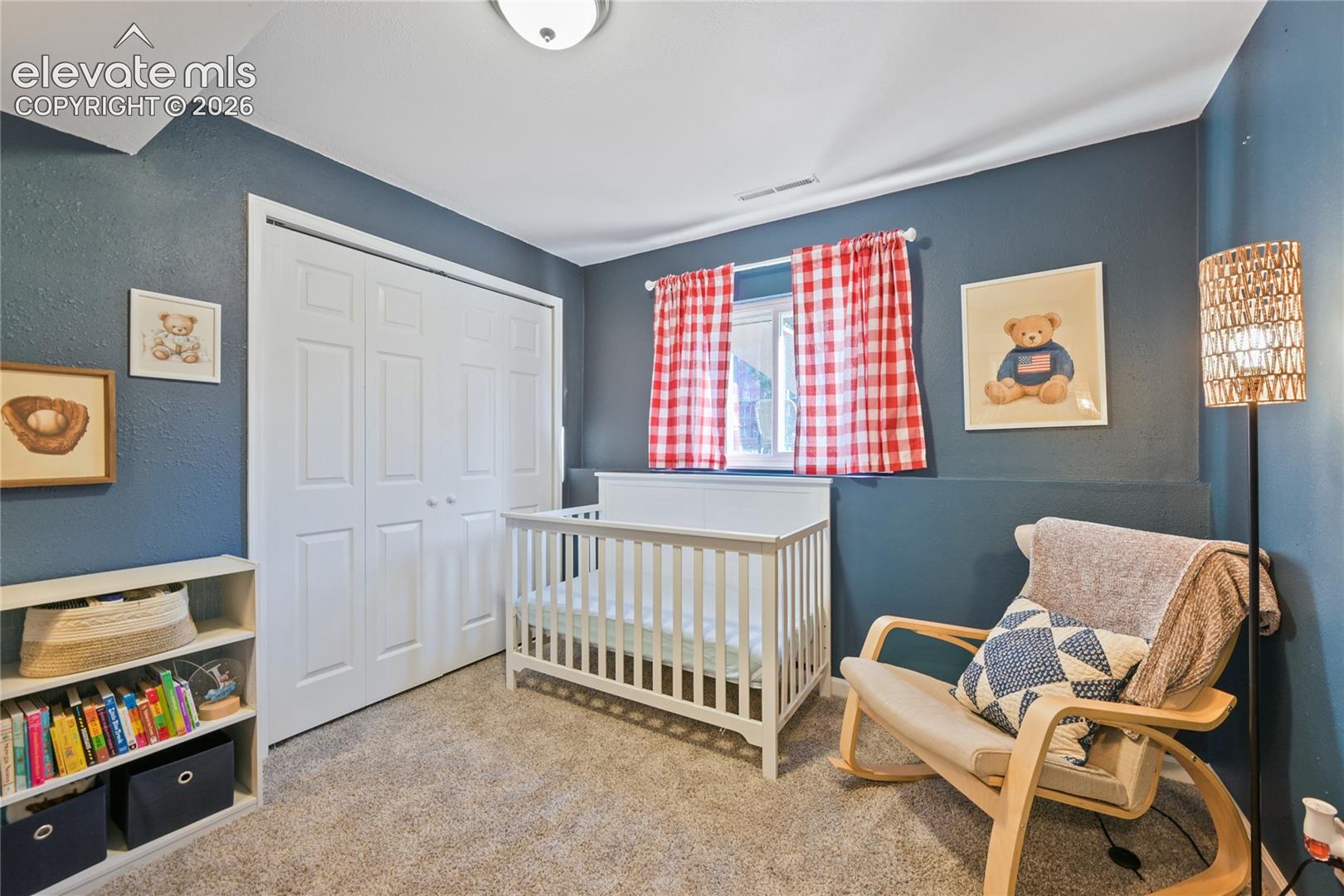 Neutral-toned carpeting, dual-pane window with white trim, and a double-door closet with panel detailing