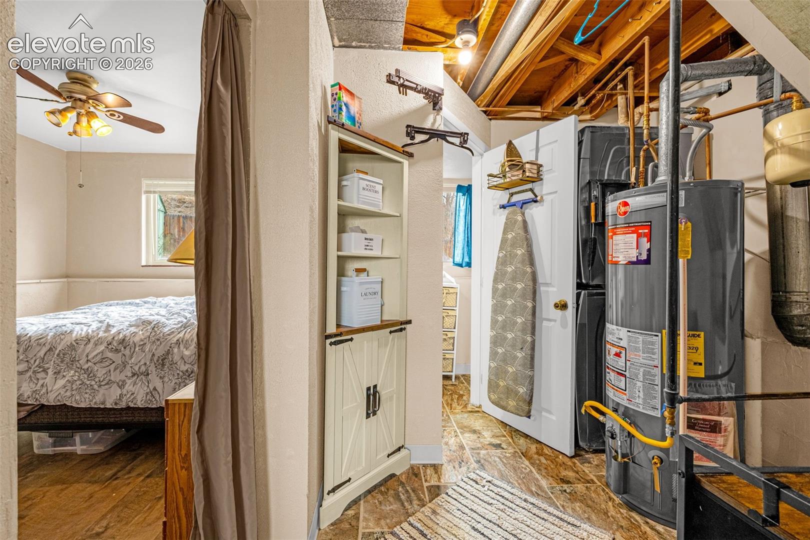 Built-in corner cabinetry with wood-toned shelving, tile flooring, and exposed wooden ceiling joists
