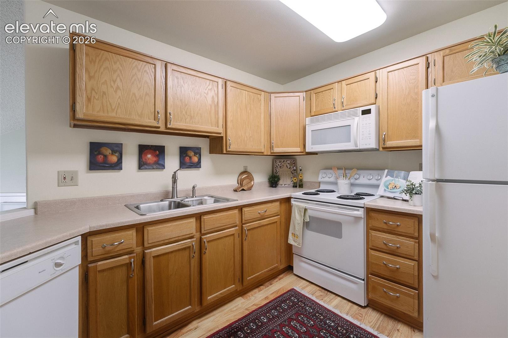  The kitchen features abundant cabinetry, generous workspace, and appliances including a range oven, dishwasher, microwave, and refrigerator.