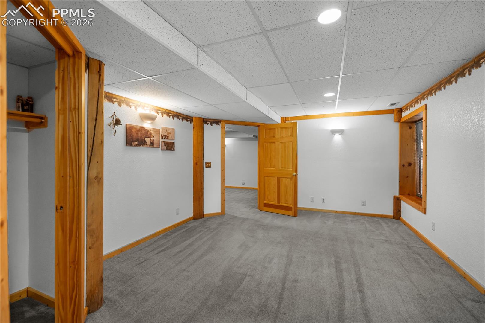 Finished basement with a paneled ceiling, carpet floors, and recessed lighting