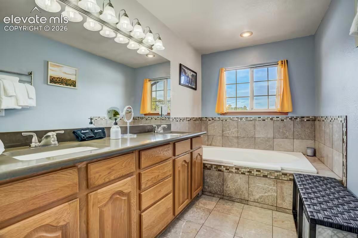 Dual vanity with a stone-finish countertop, undermount sinks, and ample wood cabinetry