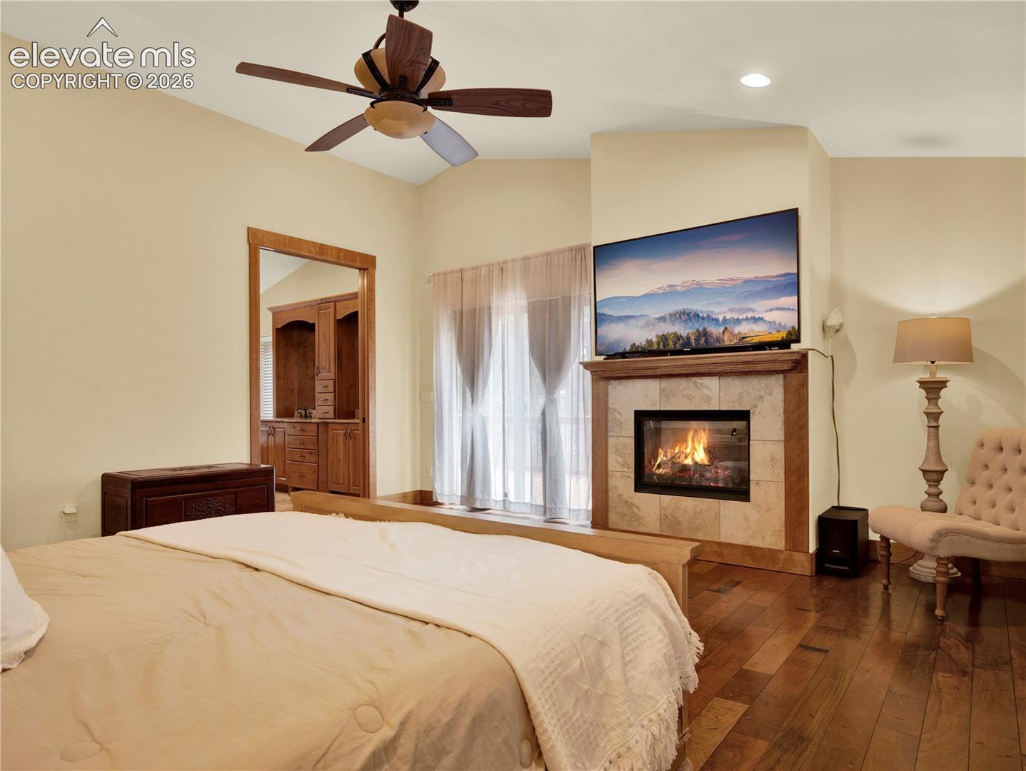 Main level primary bedroom complete with a gas fireplace and access to an outdoor deck
