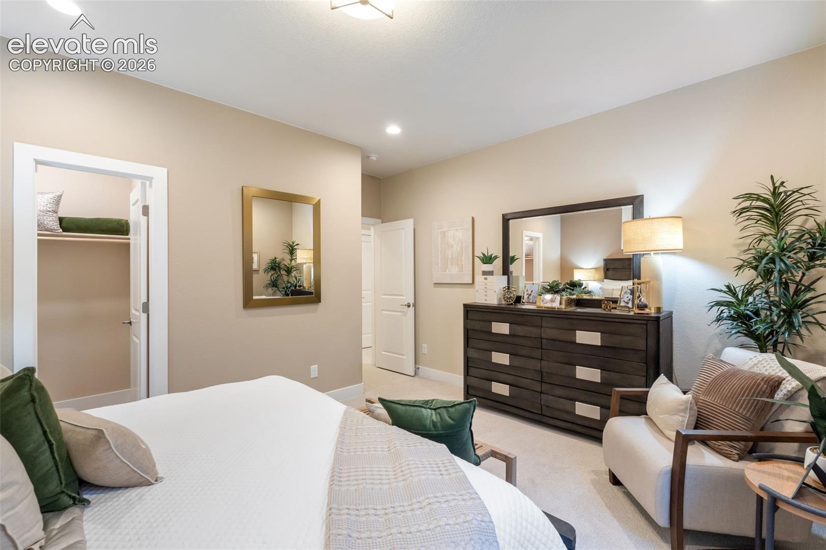 Neutral-toned interior featuring wall-to-wall carpeting, recessed lighting, and a walk-in closet with built-in shelving