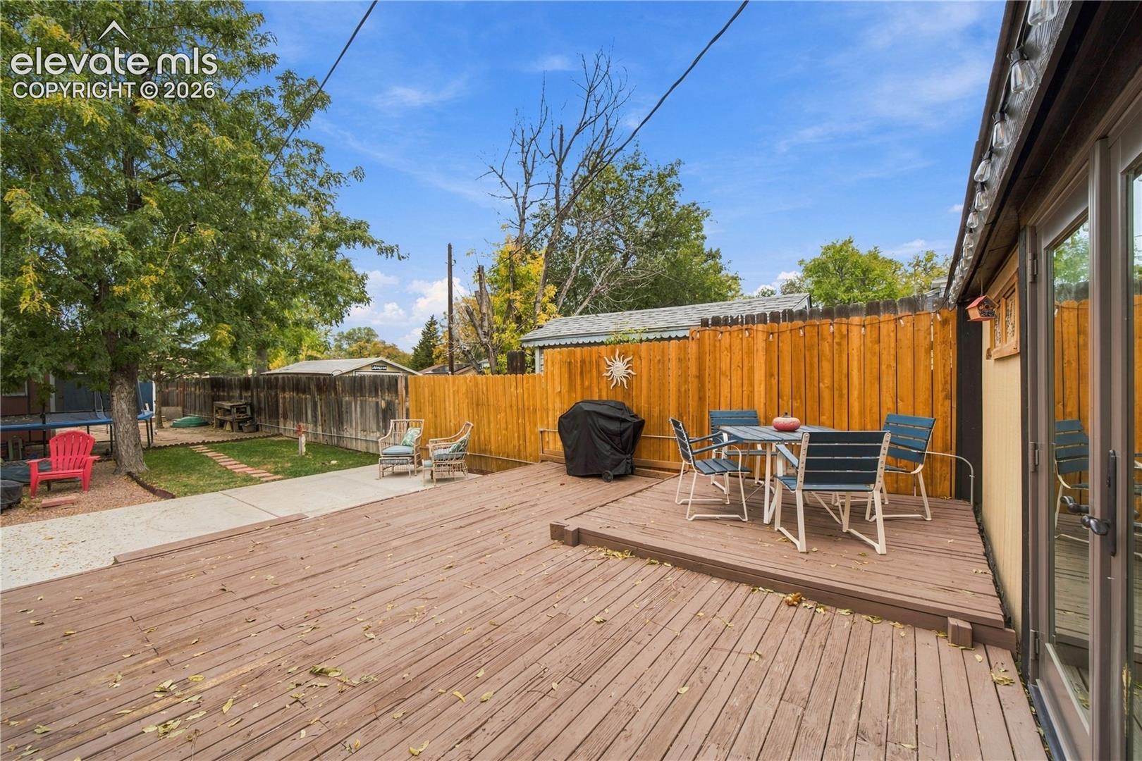 Expansive multi-level wood deck, concrete patio, and privacy wood fencing