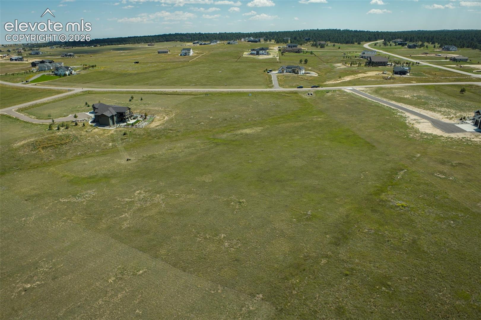 Expansive parcel of land featuring open grass topography and paved road access