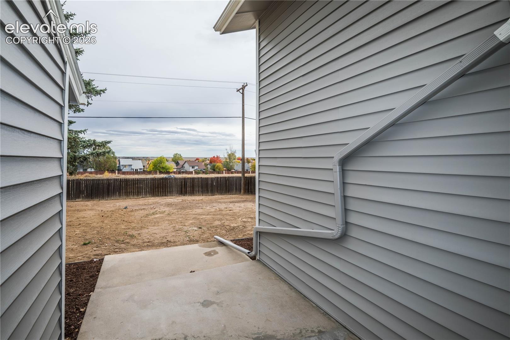 Exterior featuring horizontal lap siding, a concrete patio, and a wood privacy fence