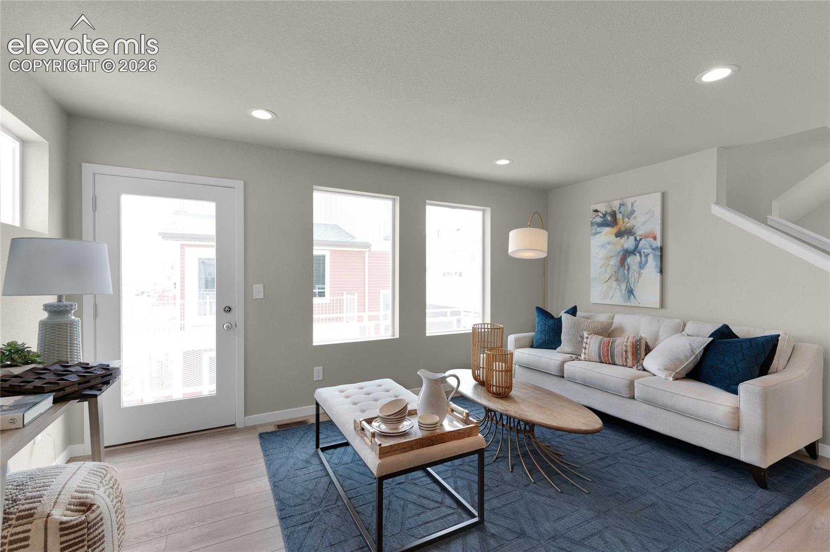 Wood-finish flooring, recessed ceiling lighting, a door with upper glass panel, and large windows
*photos of a model home*