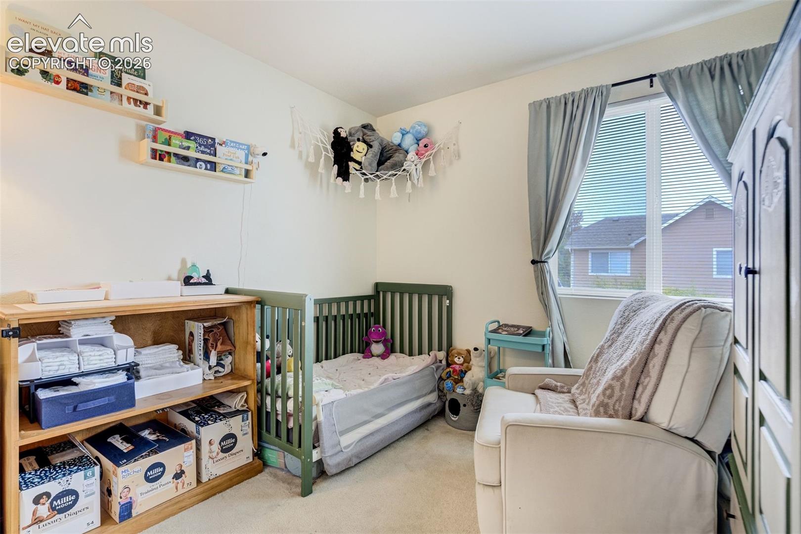 Wall-mounted shelving, built-in window blinds, and carpet flooring