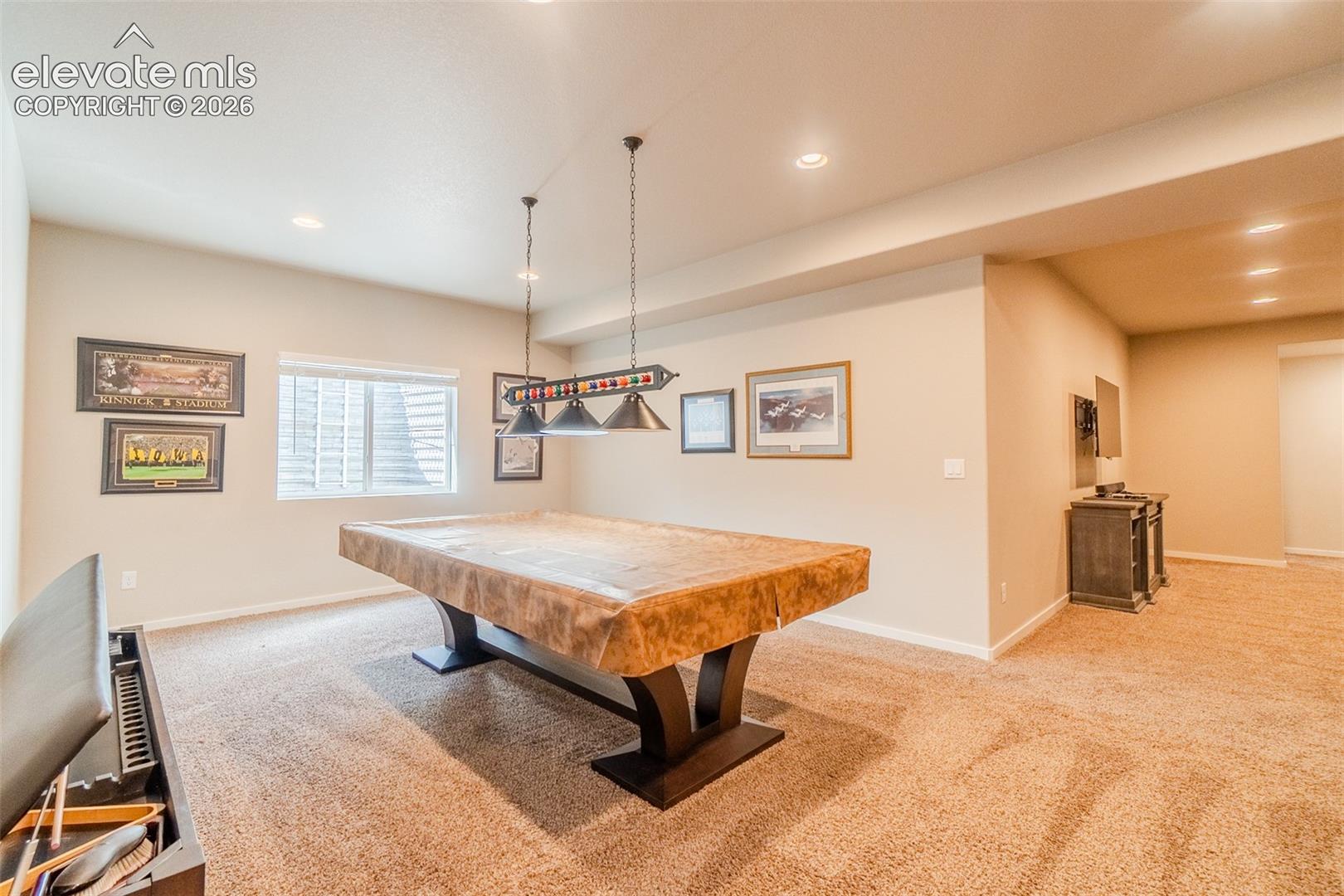 Spacious recreation room featuring recessed lighting, a window with blinds, and durable carpet flooring