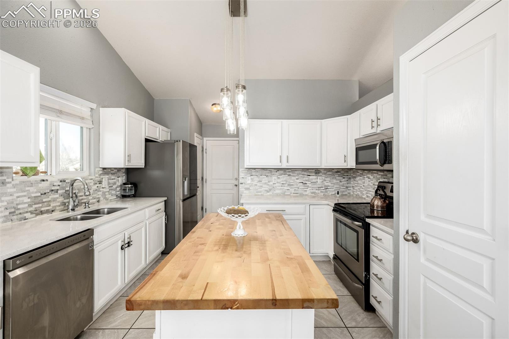 Updated Kitchen with beautiful white cabinetry and quartz/butcher block countertops