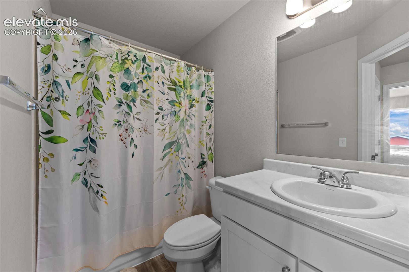 Bathroom with a single vanity, undermount sink, and wall-mounted mirror