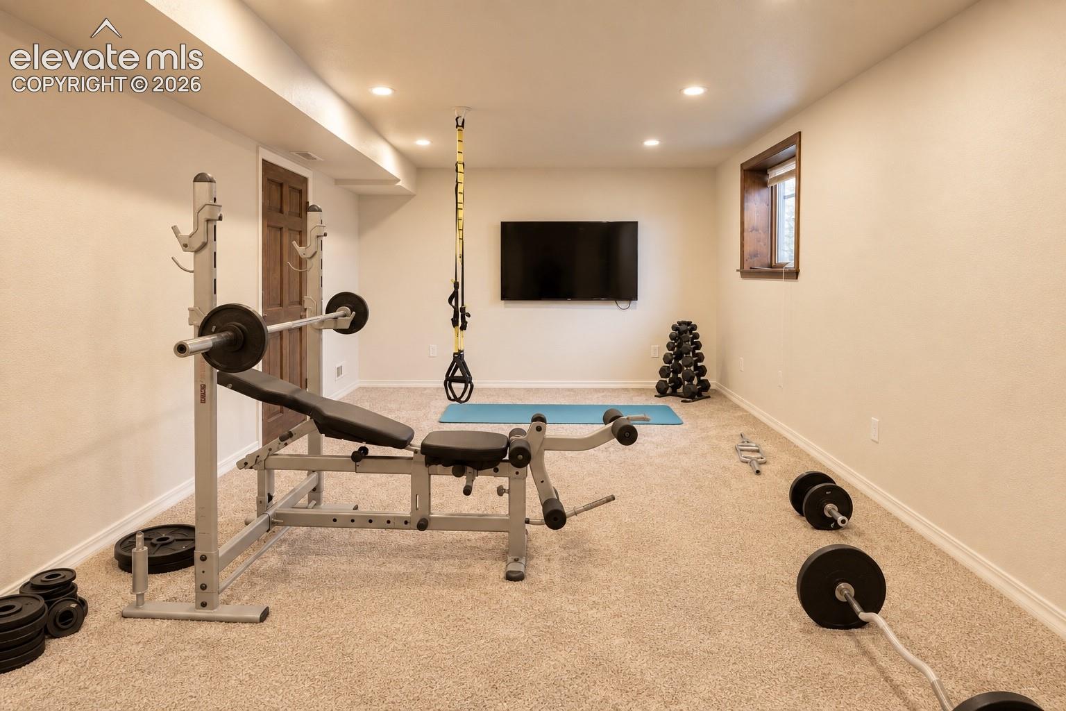 Recessed lighting, wood-finish window trim, and neutral carpet