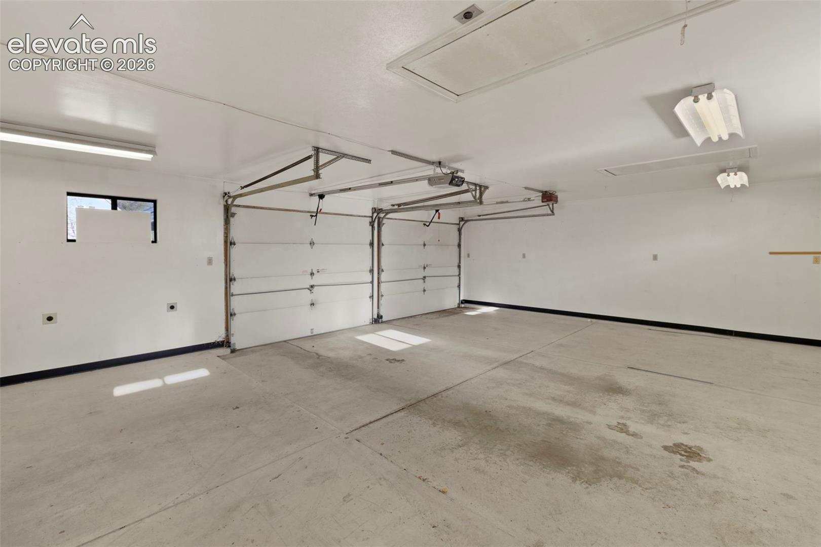 Two overhead garage doors and a concrete floor