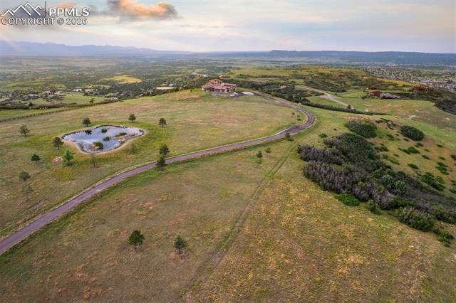 Aerial view of the full 35-acre property, private pond, and winding drive leading to the estate