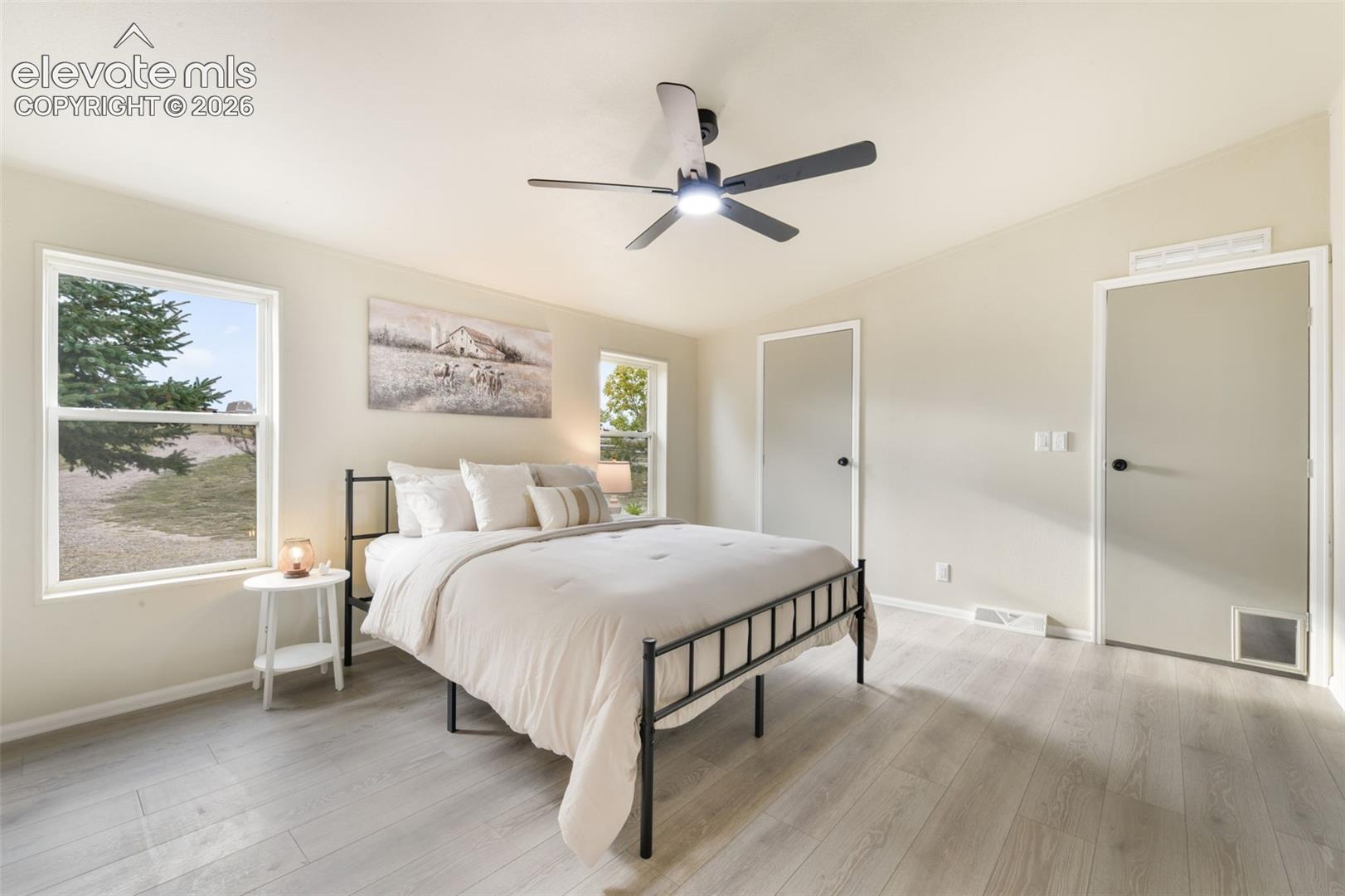 Light wood-finish flooring, vaulted ceiling, dual windows, and two interior doors