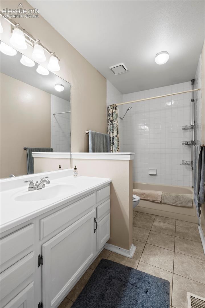 White vanity with integrated sink, chrome faucet, and dark hardware