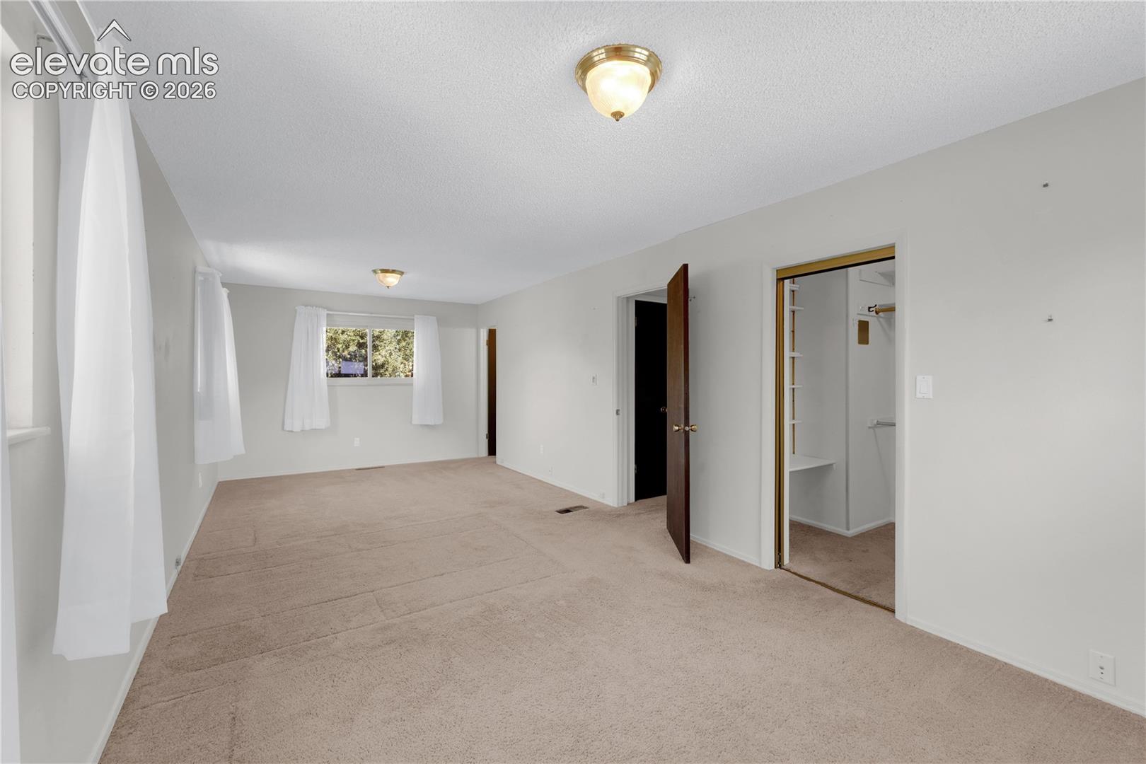 Primary Bedroom with walk-in closet and bathroom. The windows overlook the backyard.
