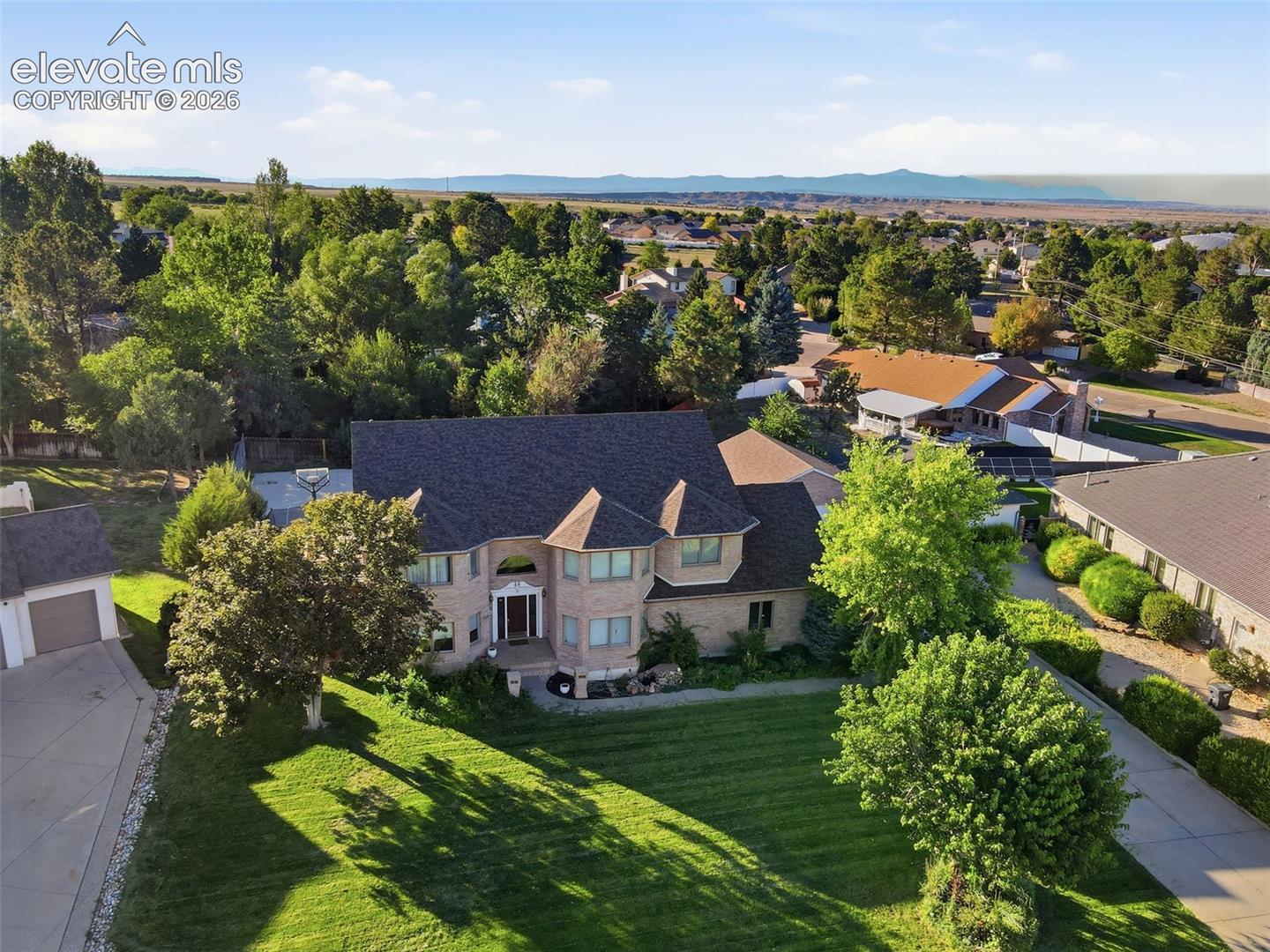 Brick exterior residence with a multi-gabled roof and turrets